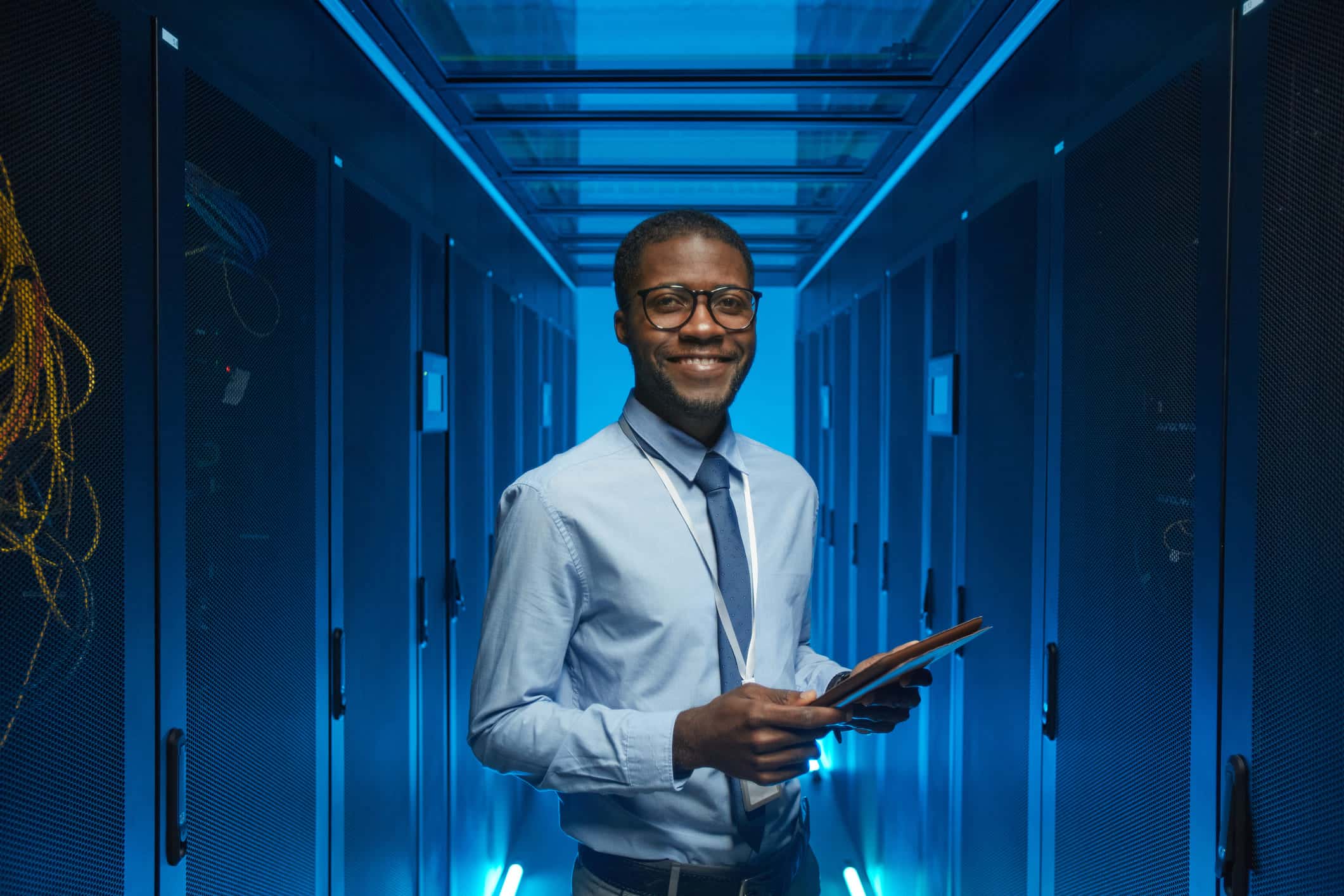 IT technician in a blue server room.